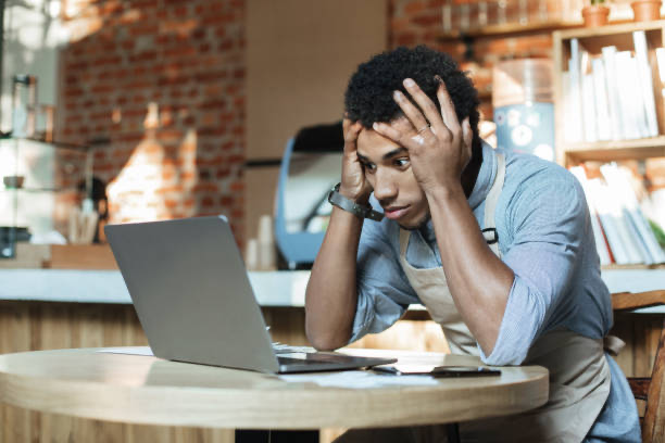 Frustrated restaurant owner dealing with paperwork and financial stress